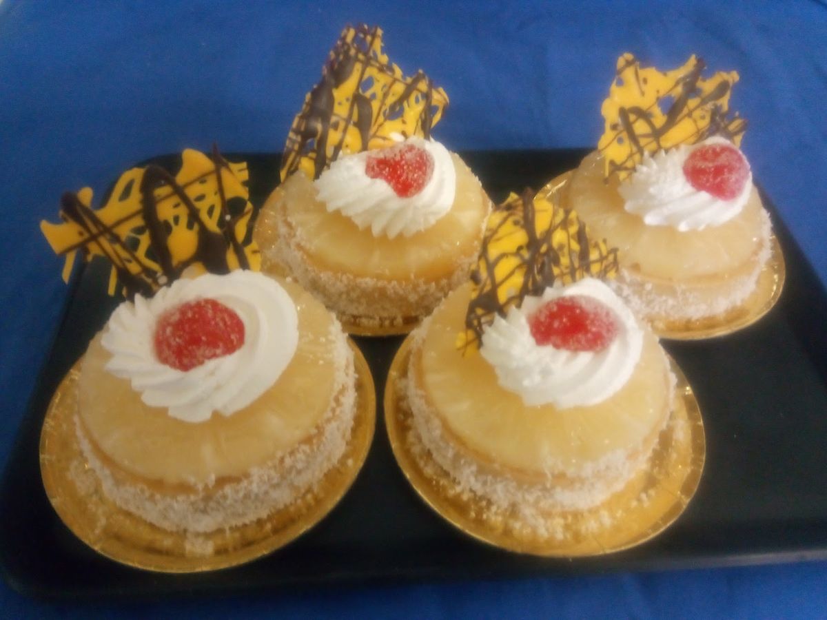 Pasteles individuales con nata, cereza y decoración de chocolate