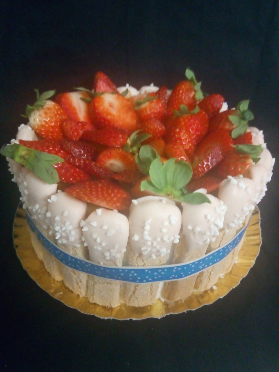 Tarta de fresas frescas rodeada de bizcochos y un lazo azul
