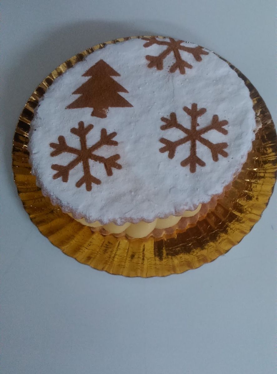 Tarta blanca decorada con un abeto y copos de nieve de canela